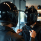 Personne ajustant un casque moto noir devant un miroir lumineux